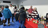 Nate Hochstetler (second from right) and Jan Hochstetler (far right) of The Hub Collective chat with visitors to their booth.   Tim Brody / Bulletin Photo