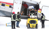 North Star Air employees load the plane. - Tim Brody / Bulletin Photo