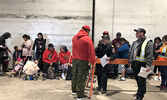 Sioux Lookout Fire Chief Rob Favot (standing centre at barrier) speaks with a Canadian Ranger while Pikangikum First Nation evacuees prepare to board a flight to a host community. - Tim Brody / Bulletin Photo