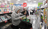 After waiting for the doors to the Red Apple store to open, customers explored the store’s selection of products as they shopped. A ribbon-cutting ceremony preceded the opening of the store.     Tim Brody / Bulletin Photo