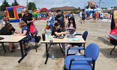 Families take part in the Tikinagan-Berry-Fun Festivities, which included face painting, temporary tattoos, as well as three big bouncy castles, one with a water slide.   Angela Anderson / Bulletin Photo