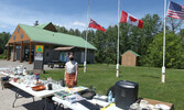 Blueberry Festival Coordinator Jessica Darling posses with donated items up for sale at outdoor yard sales last week at the Travel Information Centre, which were fundraisers for this year’s Blueberry Festival.     Tim Brody / Bulletin Photo