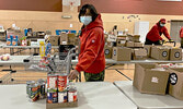 Master Corporal Rita Brisket of Lac Seul packs a food hamper for a family quarantined in its home because of COVID.     Sergeant Janet Butt, Canadian Army