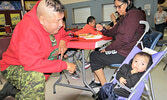 Ranger Rodney Rate plays with one-year-old Landon Quill at Pelican Falls First Nations High School. - Sergent Peter Moon / Submitted Photo