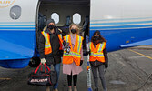 From left: Mikinakoos Board Director and North Star Air President/COO Jeff Stout, Mikinakoos Children’s Fund Executive Director, Emily Shandruk, and Director of Marketing for North Star Air Karen Matson prepare to load the hockey gear bound for Cat Lake F