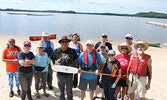 Lac Seul First Nation Chief Clifford Bull and Sioux Lookout Mayor Doug Lawrance (standing centre, both holding paddle) pose for a photo along with participants in a celebration of Equay-Minis Island on August 4.    Tim Brody / Bulletin Photo