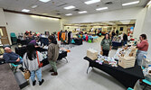 Representatives from Watkins (left) and Loving Suds (right), speak with shoppers at the Fall Market.   Andre Gomelyuk/ Bulletin Photo