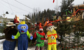 Santa Claus waves to Christmas Car Parade visitors, wishing them a Merry Christmas, along with, front from left: Smokey the Bear, Blueberry Bert, one of Santa’s elves, and Sparky the Fire Dog. - Tim Brody / Bulletin Photos