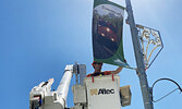 Sioux Lookout Hydro employee Adam Dinsmore replaces a municipal banner on Front Street last Thursday.     Tim Brody / Bulletin Photo