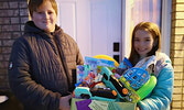 Donovan McCord (left) presents Jojo, winner of the painted rock finding draw, with a special Easter basket.    Nancy McCord / Submitted Photo