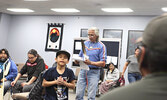 Ralph Johnson (standing, with feather) speaks to conference delegates. - Tim Brody / Bulletin Photo