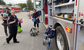 Firefighter Kelli George-Egerter shows Family Safety Night visitors the equipment in a pumper truck, including the Jaws of Life.    Tim Brody / Bulletin Photo