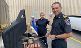 Sioux Lookout Fire Chief Bob Popovic (foreground) and firefighter Nicole Robertson serve up burgers, hot dogs and smokies during Family Safety Night.    Tim Brody / Bulletin Photo