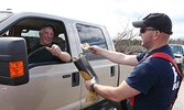 Firefighter Jeremy Funk thanks Ernie Seguin for his donation.   Tim Brody / Bulletin Photo