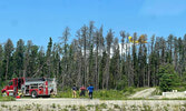 Members of the Sioux Lookout Fire Department look on as an MNRF water bomber makes a pass over a forest fire near Sioux Lookout.   Sherrie Smith / Submitted Photo