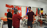 Francesco Pedrini (right) is greeted by Rotary Club of Sioux Lookout member Susan Barclay (middle) before receiving his gifts and certificates to symbolize the completion of the Rotary Canoe Trip. - Jesse Bonello / Bulletin Photos
