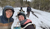 Husband and wife mushers Jesse Terry (left) and Mary England of Sioux Lookout at the John Beargrease Sled Dog Marathon. Terry is seen wishing England best of luck as she departs with their kennel’s puppy team on the last leg of the race.     Photo courtes