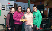 Team Mousseau accept their winning trophy. Team members from left are: Second Amanda Berman, Skip Monique Mousseau, Lead Haylee Bouchard, and Third Tristan Bouchard. - Tim Brody / Bulletin Photo