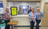 Members of the Legion Ladies Auxiliary pose in front of a take-out sign at the auxiliary kitchen, located on the upper level of the Legion.   Andre Gomelyuk/ Bulletin Photo