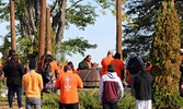 Pelican Falls First Nations High School staff and students join Victor Lyon (centre) at the memorial site where the original Pelican Lake Indian Residential School once stood.   Photo courtesy of Pelican Falls First Nations High School
