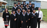 NNEC Education Director Dobi-Dawn Frenette (far left) and PFFNHS Principal Darrin Head (far right) alongside the 2021-2022 graduating class from Pelican Falls First Nations High School.    Tim Brody / Bulletin Photo