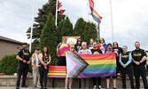 Sioux Lookout Mayor Doug Lawrance and Councillor Reece Van Breda (standing centre of progress pride flag) are joined by municipal staff, members of the Sioux Lookout OPP, and community members for a group photo prior to Lawrance proclaiming June as Gay Pr