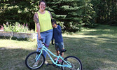 Six-year-old Bronson Greig, along with his mom Chelsey Greig, shows off the new bike he won on August 1.     Tim Brody / Bulletin Photo