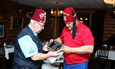 McKechnie (left) presents Larry Ross with a plaque in recognition of him and his wife’s support for Khartum Shriners fundraising efforts to help kids. - Tim Brody / Bulletin Photos