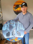 Artist Nathan Monias displays his art. The piece on the left depicting three timber wolves is titled “The Hunt”, while the piece on the right depicting two bald eagles is titled “Above the Clouds”.      Mike Lawrence/Bulletin Photos