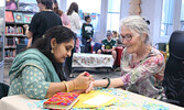 Jahanvi Patel (left) creates a piece of henna tattoo artwork upon the hand of Jennifer Hancharuk.   Tim Brody / Bulletin Photo