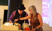 Master of Ceremonies Elliott Doxtater-Wynn and Municipal TRC member Joan Cosco light a special cake in recognition of lost birthdays.     Tim Brody / Bulletin Photo