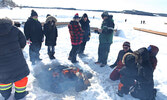 Visitors to the Town Beach on Feb. 16 warm themselves by the fire. Hot dogs and marshmallows were available for roasting. - Tim Brody / Bulletin Photo