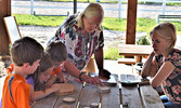 From left: Samuel Landgraff, Naomi Landgraff, and Jesse Landgraff learning about trees from Aileen Urquhart, alongside their mom Amanda Landgraff. - Jesse Bonello / Bulletin Photo