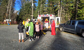 Trunk or treat volunteers make the rounds in the Cedar Bay parking lot, including a visit to the KDSB Ambulance Services trunk.      Mike Lawrence / Bulletin Photo