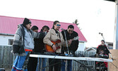 Creighton Beardy (playing the guitar) is supported by the Quequish’s and Elders as he performs a song in honour of the daughter he lost in the fire. - Tim Brody / Bulletin Photo