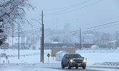 A vehicle travels down Wellington Street during a snow storm last winter.      Bulletin File Photo