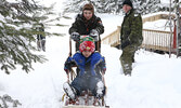 Scout Hayden Price steadies a sled Beaver Sean Brody is riding in, while fellow Scout Carson Pettit pulls the sled up the hill using a pulley. Scout Leader Jeremy Funk (right) supervises.  - Tim Brody / Bulletin Photo