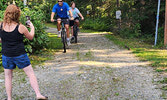 Nancy McCord snaps a photo as husband Mike McCord and son Ethan McCord of Team McCord finish the Cedar Bay Family Adventure Course.   Angela Anderson / Bulletin Photo